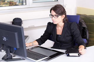paralegal working at her desk in front of the computer