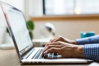 a paralegal certificate student typing on their laptop